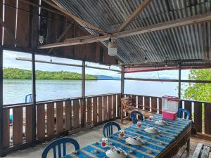 a table on a deck with a view of the water at Tapor Pandera Homestay in Besir
