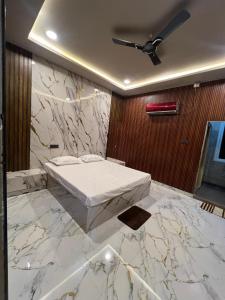 a bedroom with a bed and a marble wall at N R GUEST ROOMs in Warangal