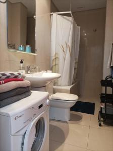 a bathroom with a washing machine and a sink at Adeje Paradise dreams in Playa Paraiso