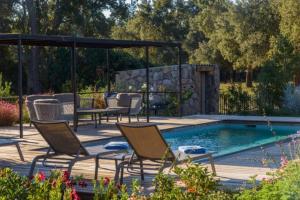 a patio with chairs and a swimming pool at Lodge Les Oliviers Di Lecci in Lecci