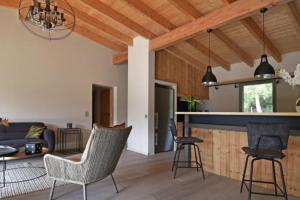 a kitchen and living room with wooden ceilings at Lodge Les Oliviers Di Lecci in Lecci