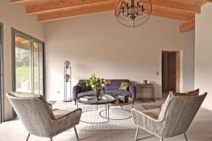 a living room with a couch and chairs and a table at Lodge Les Oliviers Di Lecci in Lecci
