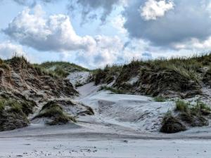 a sandy beach with snow and grass on it at 6 person holiday home in Strandby in Strandby