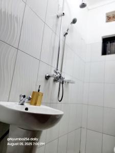 a white bathroom with a sink and a shower at Vintage Room - Nostalgic charm for couples in Gulu +26 photos