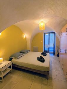 une chambre avec un grand lit dans une pièce dans l'établissement Le Mistral - Pont du Gard - Cozy & Intime - WiFi fibre -TV, à Saint-Bonnet-du-Gard