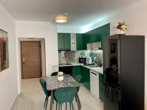 a kitchen with green cabinets and a table with chairs at Casa Vista Premium 2BR Apartment with Free Parking in Sofia