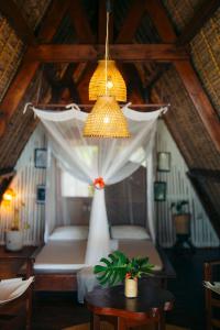 a room with a bed and a chandelier at Aurora Lodge in Ile aux Nattes