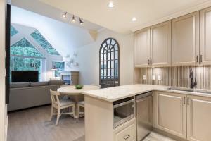 a kitchen with a table and a living room at Woodrun Lodge 616 | Stylish Top Floor Ski-In & Out Condo by Upper Village w/ Hot Tub, Pool, Parking in Whistler +23 photos