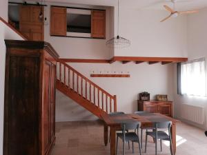ein Esszimmer mit einem Tisch und einer Treppe in der Unterkunft Maison de 80m2 avec cour fermée et sécurisée in Crozes-Hermitage