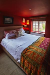 een slaapkamer met een groot bed in een rode kamer bij Heale Farm Cottage in Trentishoe