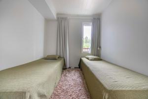 two beds in a room with a window at Lomahuoneisto Skivillas 26 B 6 in Ukkohalla
