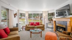 a living room with couches and a fireplace at Woodrun Lodge 214 | Ski-in-Ski-Out Condo, Heated Pool, Hot Tub, Gym in Whistler