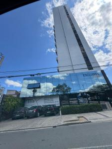 a parking lot with cars parked in front of a building at Flat de alto padrão no centro da cidade in Campina Grande