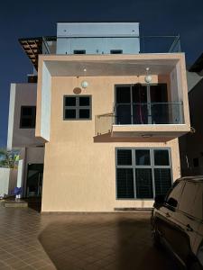 una casa con un coche aparcado delante en Aarons Place 4BR home 10mins to Airport Prime Area Fast WIFI, en Accra