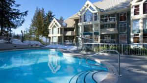 a swimming pool in front of a apartment building at Woodrun Lodge 414 | Cozy Ski-In Ski-Out Condo w/ Shared Hot Tub, Pool, Fireplace, & Parking in Whistler