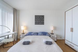 a white bedroom with two beds and two lamps at Ferienwohnung 2 Schlafzimmer W47 in Bern +7 photos