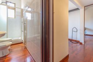 a bathroom with a toilet and a glass door at Modern Two-Room Apartment With Quiet Courtyard in Bologna