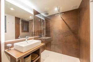a bathroom with a white sink and a shower at Chalet U Picculu Di Arasu in Sainte-Lucie de Porto-Vecchio