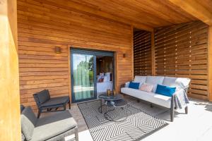 a patio with a couch and a table and chairs at Chalet U Picculu Di Arasu in Sainte-Lucie de Porto-Vecchio