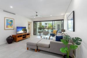 a living room with a couch and a tv at Infinity's Edge - Poolside Retreat at Temple Resort in Craiglie