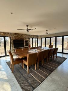 comedor grande con mesa larga y sillas en Makhato 100 Bush Lodge, en Bela-Bela