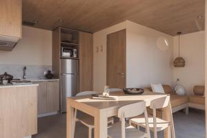 a kitchen and dining room with a table and chairs at Camping Lou Broustaricq in Sanguinet
