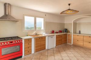 cocina con fogones rojos horno superior al lado de una ventana en Villa Vista Di Pinarello, en Pinarellu 33 fotos más