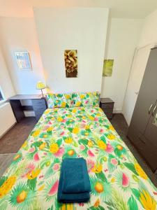 a bedroom with a bed with a floral bedspread at BIG double room Attached Shower near to city center in Nottingham