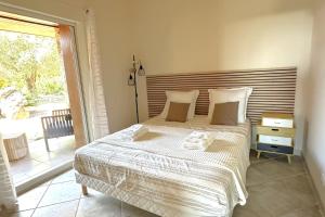 une chambre avec un lit et une grande fenêtre dans l'établissement Villa Taglio Rosso Di Santa Lucia, à Sainte-Lucie de Porto-Vecchio