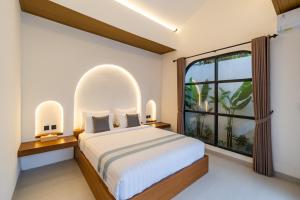 KrambitanにあるVilla Amerta Stynn - Stylish 2BR Tropical Retreat Villa near Kelating Beachの大きなベッドと大きな窓のある寝室 +18枚の写真