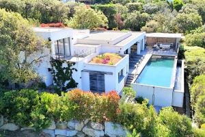 an aerial view of a house with a swimming pool at Villa Cala Rossa Di Lecci in Lecci