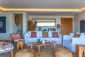 a living room with a white couch and a table at Villa Cala Rossa Di Lecci in Lecci +41 photos