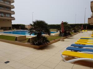 a row of lounge chairs next to a swimming pool at Facing the Sea in Furadouro