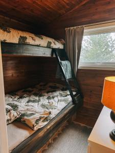 una litera en una habitación con ventana en Koselig eldre hytte, en Hammerfest