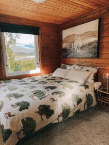 Un dormitorio con una cama con una ventana grande. en Koselig eldre hytte, en Hammerfest