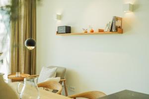 a dining room with a table and chairs and a shelf at oceanHUTS Coxos Adults Only from age 14 in Ericeira +75 photos
