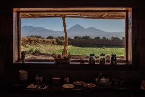a window in a room with a view of a field at Planeta Atacama Lodge in San Pedro de Atacama