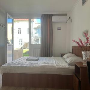 a bedroom with a large bed with a window at King13 in Kutaisi