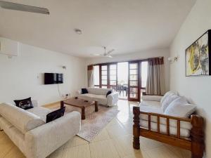 a living room with two couches and a table at Wincome Beachfront Apartments in Mombasa