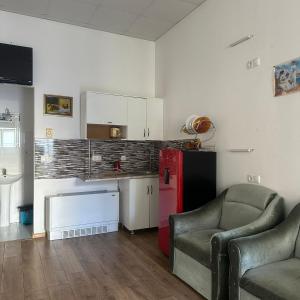 a living room with two chairs and a red refrigerator at King13 in Kutaisi +24 photos