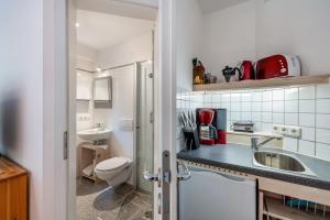 a small bathroom with a sink and a toilet at Ferienapartment Remke in Starnberg +17 photos
