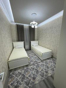 Un dormitorio con dos camas y una lámpara de araña. en Luxury Central Apartments Samarkand, en Samarkand