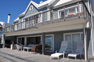 布菲尔斯巴埃Main beachfront house Halleluja II, Buffalo Bay的房屋内带桌椅的甲板