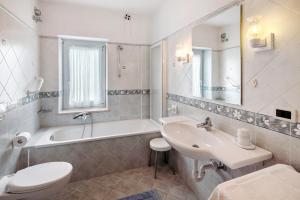 un bagno con lavandino, WC e vasca di Casa Al Sole Moena a Moena Altre 18 foto