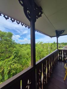 a balcony with a view of the jungle at Homestay Sayang Salmah in Balik Pulau