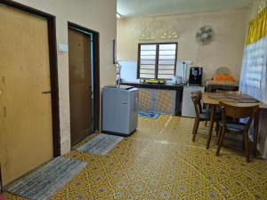 a kitchen with a table and a small refrigerator at Homestay Sayang Salmah in Balik Pulau