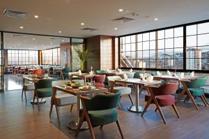 a restaurant with tables and chairs and windows at Dedeman Kayseri in Kayseri