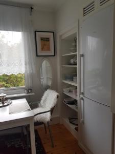 a kitchen with a refrigerator and a table and a chair at Studiolägenhet i villa in Huddinge +18 photos