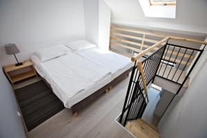 ein kleines Schlafzimmer mit einem Bett und einer Treppe in der Unterkunft Dom Przy Plaży w Dąbkach in Dąbki