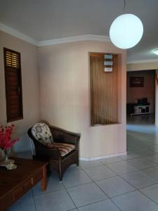 a living room with a chair and a table at Casanostra44 in Jenipabu